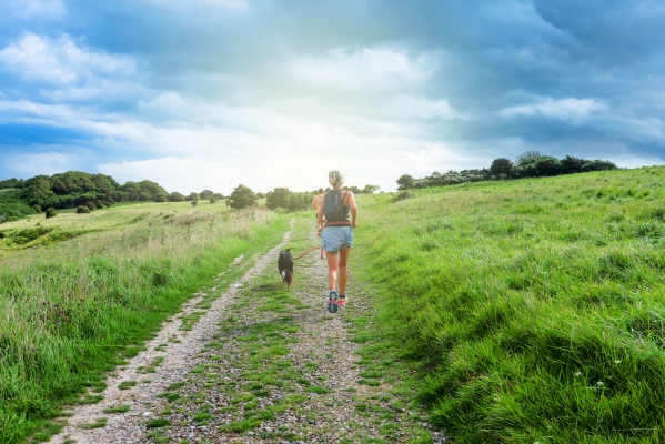 Courir avec son chien : Femme qui court avec son chien sur un sentier