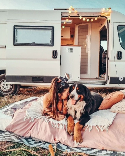 Justine WDM et Montana couchés sur un grand coussin à côté du van